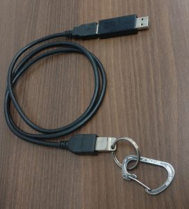 Photo of the BusKill hardware, including a carabiner, keyring, usb drive, usb extension able, and magnetic usb breakaway adapter