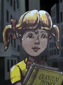 Image shows a cardboard cutout of a blonde-haired 8-year old girl, holding a book titled "Quantum Physics", with a bullet hole in between her eyebrows